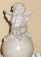 An angel sitting on a sphere sending a kiss