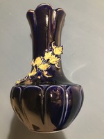 Kobalt színű porcelán,  aranyozott szélű váza, oldalán borostyán díszítés.