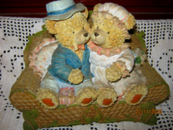 Teddy bear couple on sofa with money box