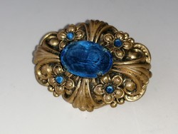 Old brooch badge decorated with blue stones