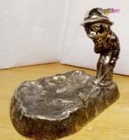 Golf grandmaster in dilemma. Silver plated ash decorated with a golfer figure.