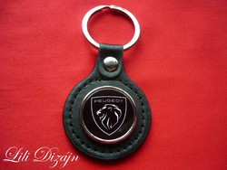 Peugeot (new logo) circular metal keychain on a leather background