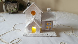 Winter, snowy wooden cottage with LED lighting