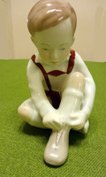 Aquincumi porcelán, cipőjét fűző kisfiú