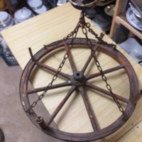 Old chariot, horse-drawn wooden wheel chandelier.