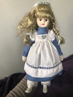 Beautiful blond porcelain doll with old blond hair in blue dress