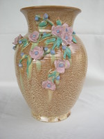 A large vase decorated with hoppy ceramic flowers