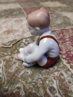 Porcelán cipőjét kötő kisfiú