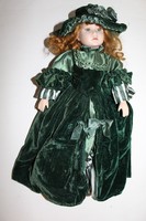 A doll with a large porcelain body, dressed in velvet
