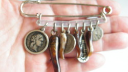 Old safety pin badge with charms