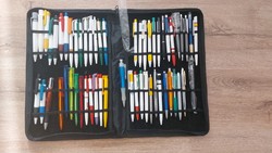(K) many ballpoint pens in a large pen folder