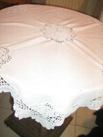 A beautiful tablecloth with a hand-crocheted edge and a round insert
