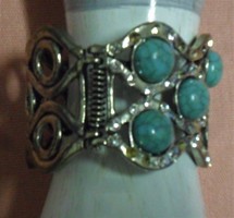 Silver metal bracelet with turquoise stones and rhinestones.