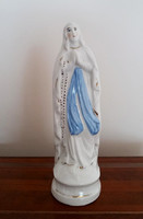 Old religious porcelain statue of Mary with relics