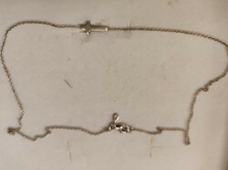 Silver necklace decorated with a blue cross