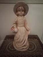 Ceramic statue of a little girl in a hat with a basket of apples