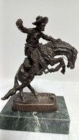 Frederic Remington bronze statue, after the work of the bronco buster sculptor, with a marble/granite base.