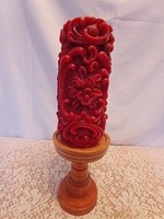 A large block of candles with a carved effect with a wooden candle holder