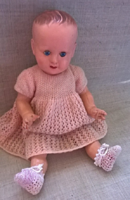 Sleeping baby in old preserved condition in a small knitted dress and shoes