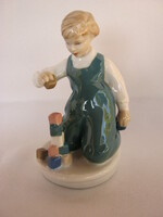 Little boy playing with royal dux porcelain building blocks