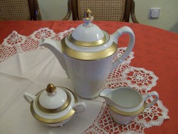 Porcelain teapot with a beautiful golden border, on a snow-white base, sugar holder and milk spout