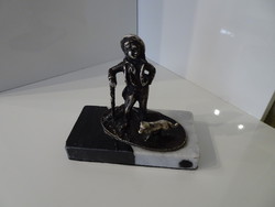 Antique statue of a boy walking with his dog on a marble foot.