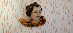 Old, carved wooden putto head angel