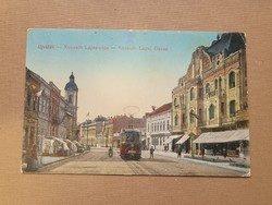 Újvidék Kossuth Lajos utca Magyar Nemzeti zászlókkal üzletekkel villamossal 1916