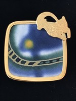 Hand-painted, silk-inlaid brooch with a gilded frame and a mountain goat