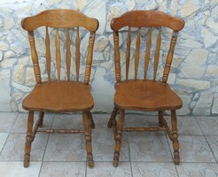A pair of carved wooden chairs with turned backs