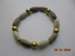 Bracelet made of beige, greenish and gold colored wooden beads