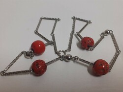 Thick stainless steel square necklace with red coral colored stones on it