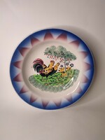Old painted folk wall plate made of hard earthenware with rooster