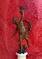 Cupid with olive branch. Antique statue on a marble plinth.
