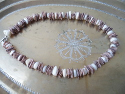 A necklace or bracelet made of small pieces of polished seashells