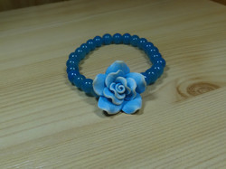 Bracelet made of blue glass pearls, decorated with fimo blue roses.