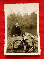 Antik öltönyös férfiú a vízparton kerékpárral kicsi fotó a képek szerint