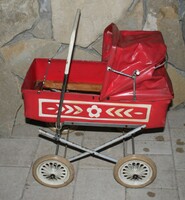 Old retro stroller in red color.
