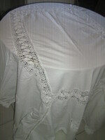A beautiful white antique tablecloth with a hand-crocheted edge and insert