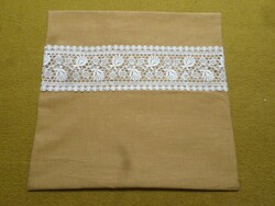 Linen cushion cover with lace inserts.