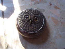 A small box with an owl's head, maybe powder...