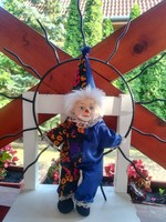 Wrought iron clown with a porcelain head sitting on a sunbed, the sun is 44 cm in diameter
