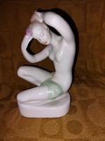 White porcelain figure of a girl combing her hair