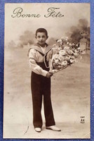 Antique greeting photo postcard of a little boy in sailor clothes with a bouquet of roses