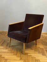 Retro armchair with brown plush cover and wooden armrests