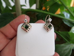 A pair of gold earrings with green tourmalines and brils