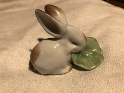 A small porcelain statue of a rabbit bunny eating cabbage leaves
