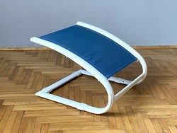 Bent metal footrest next to armchair