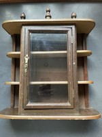 A very nice small wall cabinet, with a glazed door in the middle, a copper handle, and small shelves on both sides