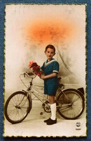Old nostalgia photo postcard - little boy with a bicycle with a rose from 1943